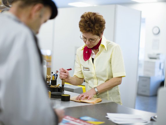 Le bruit du tampon validant un paiement dans le "livret jaune" d'un client se fait de moins en moins entendre dans les offices postaux (archives) . © KEYSTONE/MARTIN RUETSCHI