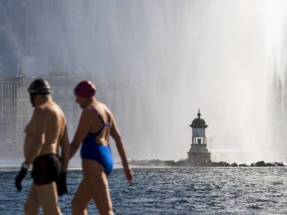 Des baigneurs vont aller piquer une tête dans le lac Léman non loin du Jet d'eau de Genève par un chaud dimanche d'hiver: c'était le 23 février dernier. © KEYSTONE/MARTIAL TREZZINI