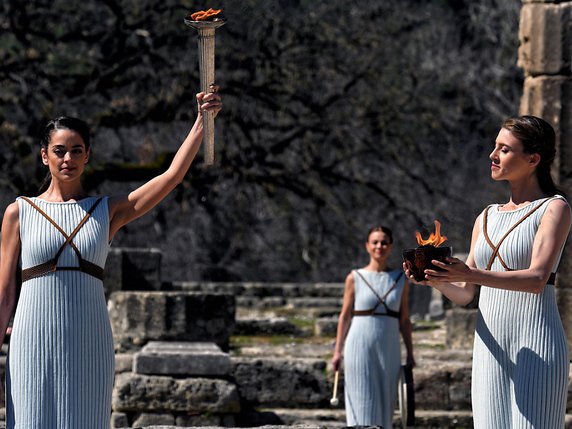 L'actrice grècque Xanthi Georgiou (à gauche) porte la flamme olympique à Olympia. © Keystone/EPA/VASSILIS PSOMAS