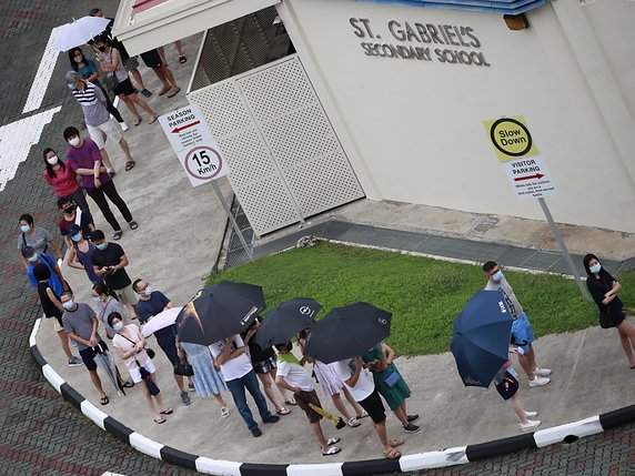 Les bureaux de vote sont restés ouverts deux heures de plus, en raison des mesures sanitaires qui ont provoqué de longues files d'attente, le vote étant obligatoire à Singapour. © KEYSTONE/EPA/HOW HWEE YOUNG