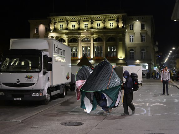 Comme ils l'avaient indiqué la veille, les manifestants pour le climat ont déplacé mardi matin leurs tentes pour faire de la place au marché hebdomadaire. © KEYSTONE/ANTHONY ANEX