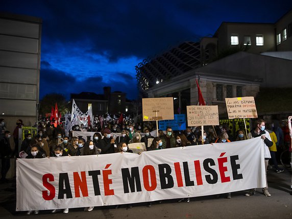 Plusieurs centaines de personnes ont défilé mercredi soir à Lausanne pour demander une meilleure considération du personnel de la santé. © KEYSTONE/JEAN-CHRISTOPHE BOTT