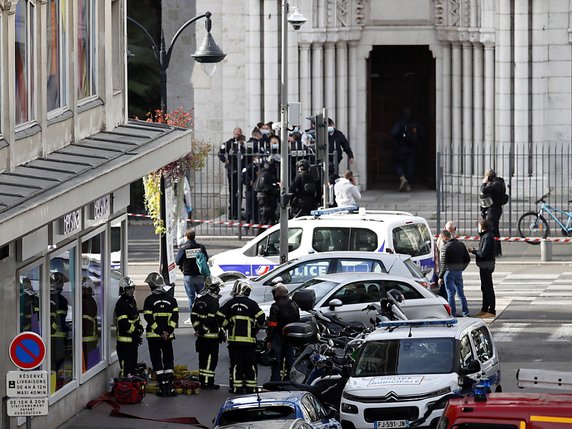 Agents de police devant l'église Notre-Dame, où l'attaque a eu lieu. © KEYSTONE/EPA/SEBASTIEN NOGIER