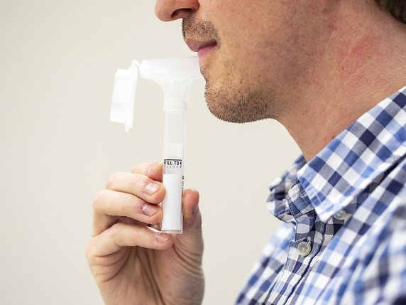 Pour effectuer l'autotest de coronavirus, il faut cracher dans une sorte de paille en entonnoir. © Keystone/ALEXANDRA WEY