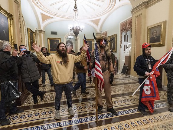 Jacob Chansley (qui tient le drapeau américain ci-dessus) est un partisan de QAnon, cette mouvance complotiste d'extrême-droite qui a vu l'intrusion dans le Capitole comme un triomphe. © KEYSTONE/AP/Manuel Balce Ceneta