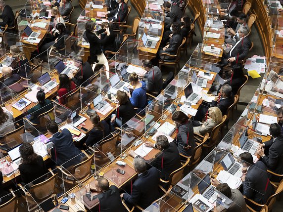 Les parlementaires seront toujours séparés par des plexiglas et masqués lors de la session qui commence lundi (archives). © KEYSTONE/PETER KLAUNZER
