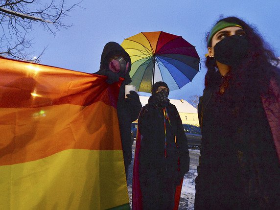 Activistes des droits humains avec le drapeau symbole des LGBTI devant le tribunal. © KEYSTONE/AP/CZAREK SOKOLOWSKI