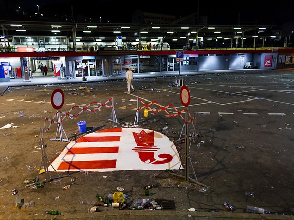 Le drapeau du canton du Jura, peint sur le sol de la Place de la gare de Moutier, n'était déjà plus complet lundi matin, des bouteilles cassées dessus ayant fait couler la peinture. © KEYSTONE/JEAN-CHRISTOPHE BOTT