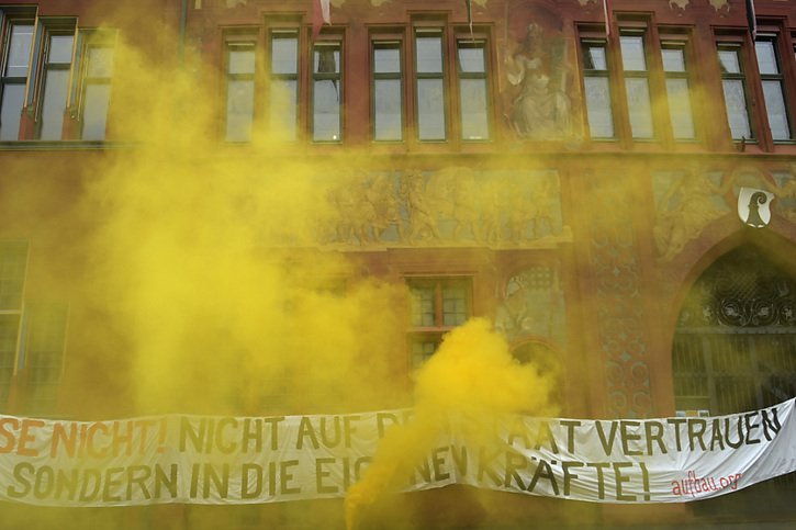 Banderoles et torches en couleur lors de la manifestation samedi matin à Bâle. © KEYSTONE/Georgios Kefalas