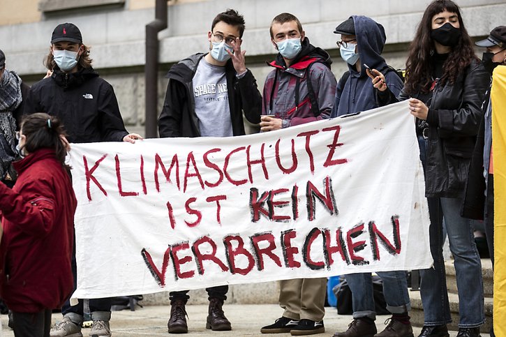 Des militants pour la protection du climat ont mené mercredi une action de solidarité devant le bâtiment du tribunal. Sur la photo, une banderole souligne que "la protection du climat n'est pas un crime". © KEYSTONE/ALEXANDRA WEY