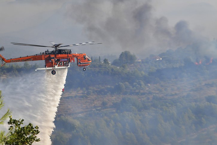 Un hélicoptère lutte contre le feu près de l'ancienne Olympie. © KEYSTONE/AP/Giannis Spyrounis