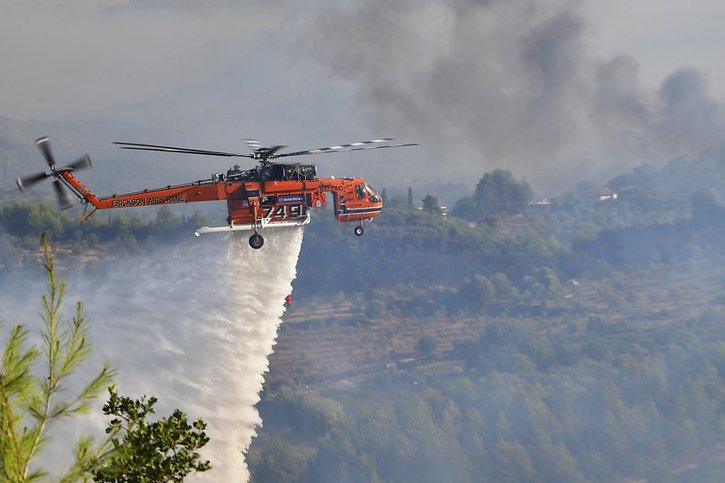 Un hélicoptère lutte contre le feu près de l'ancienne Olympie. © KEYSTONE/AP/Giannis Spyrounis