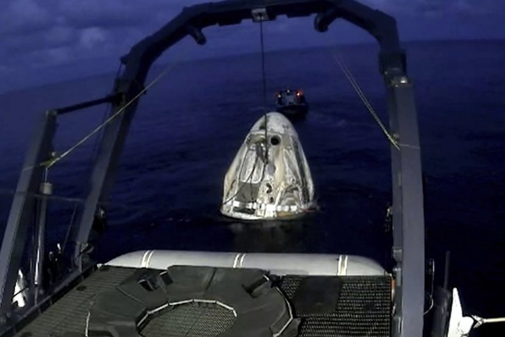 Un bateau de SpaceX récupère la capsule Dragon après son amerrissage dans l'océan Atlantique, au large de la Floride. © KEYSTONE/AP