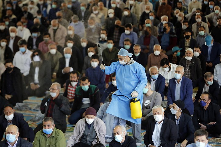 Des centaines de fidèles étaient ainsi présents dans la salle de prière de l'Université de Téhéran, pendant que des employés vaporisaient les lieux avec des produits désinfectants. © KEYSTONE/EPA/ABEDIN TAHERKENAREH