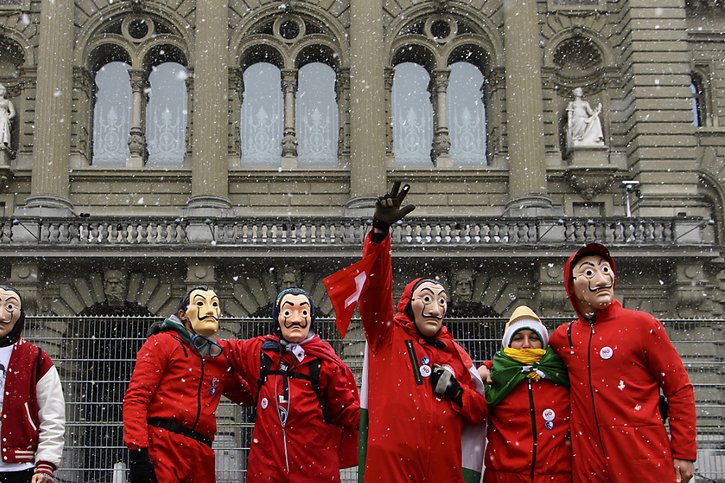 Certains protestataires avaient endossé les costumes de la série "La casa de papel". © KEYSTONE/ANTHONY ANEX