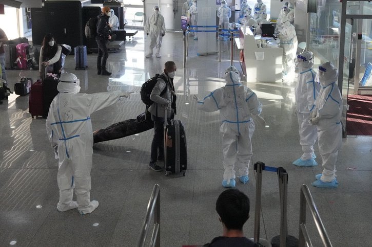 A l'aéroport de Pékin, les nouveaux arrivants sont accueillis par un comité sanitaire impressionnant. © Keystone