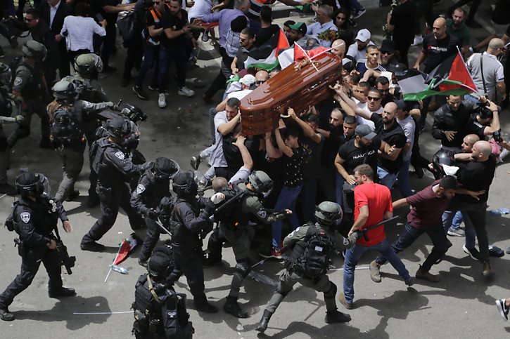La police israélienne s'en prend à la foule en deuil transportant le cercueil de la journaliste assassinée. © KEYSTONE/AP/Maya Levin