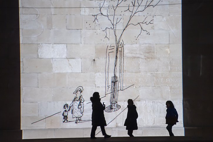 Des personnes observent des dessins de Jean-Jacques Sempe dans le cadre d'un parcours de projections nocturnes avec pour theme " Un printemps avec Sempé " autour du Parc des Bastions à Genève, au printemps 2021. © KEYSTONE/MARTIAL TREZZINI