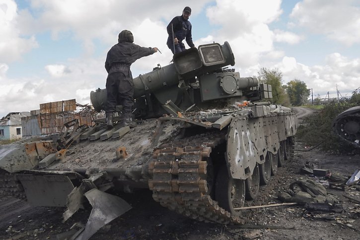 Des soldats ukrainiens se préparent à remorquer un char pris aux forces russes dans la ville de Kupyansk, près de Kharkiv, qu'ils ont récemment reprise. © KEYSTONE/EPA/VASILIY ZHLOBSKY