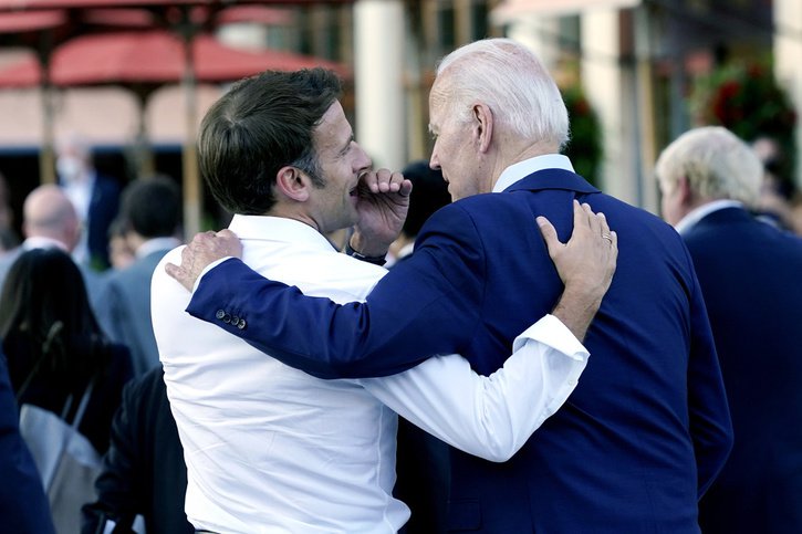 Le président français Emmanuel Macron chuchote au président américain Joe Biden après leur dîner au sommet du G7 à Elmau, en Allemagne, dimanche 26 juin 2022. © KEYSTONE