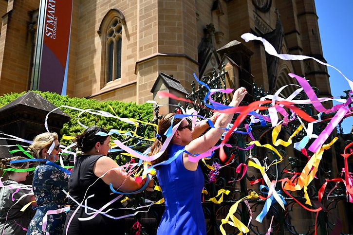 Des victimes de violences sexuelles ont attaché des rubans aux grilles de la cathédrale de Sydney, en signe de solidarité avec d'autres victimes. © KEYSTONE/EPA/DAN HIMBRECHTS