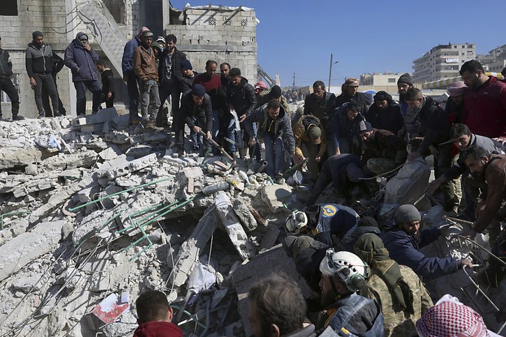 Sauveteurs et résidents s'activent dans les décombres de la ville de Harem, en Syrie, près de la frontière turque. © KEYSTONE/AP/Ghaith Alsayed