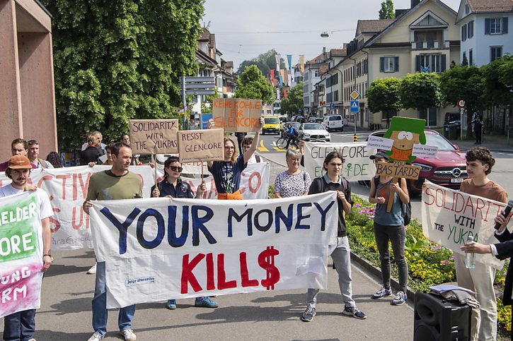"Votre argent tue" pouvait-on lire sur une des banderoles présentées par les manifestants devant l'assemblée du géant suisse des matières premières Glencore vendredi à Zoug. © KEYSTONE/URS FLUEELER