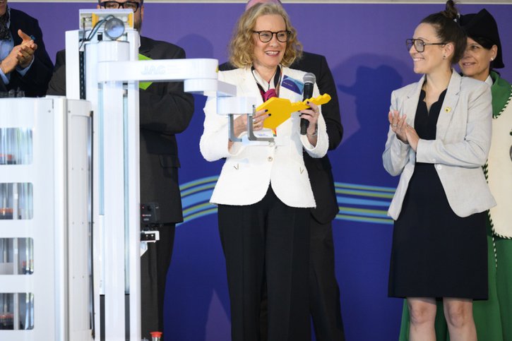 Un robot donne une clé symbolique à Belén Garijo, CEO du groupe Merck (à gauche) et à Séverine Evequoz (à droite), présidente du Grand Conseil vaudois. © Keystone/LAURENT GILLIERON